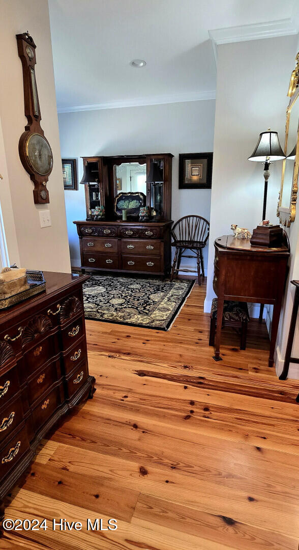 interior space featuring ornamental molding and light wood-type flooring