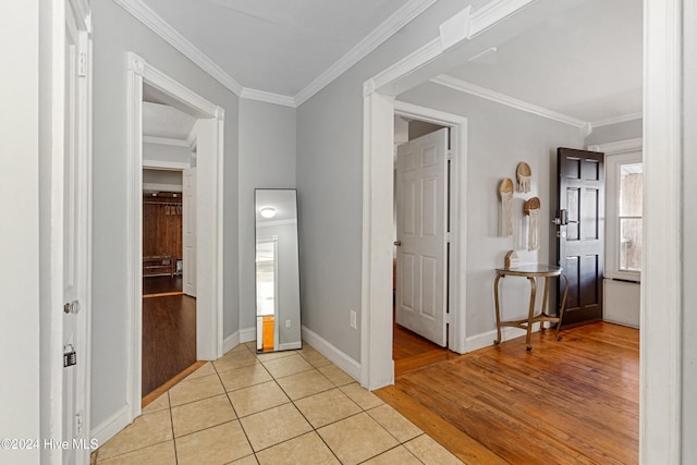 hallway featuring crown molding and light hardwood / wood-style flooring