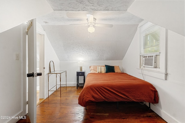 bedroom with wood-type flooring, a textured ceiling, vaulted ceiling, and ceiling fan