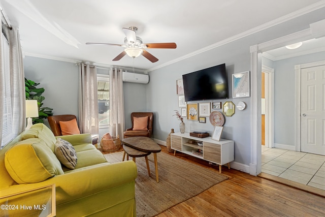 living room featuring light wood-type flooring, an AC wall unit, ceiling fan, and crown molding