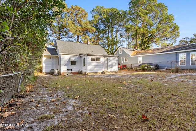 rear view of house featuring a yard and central AC