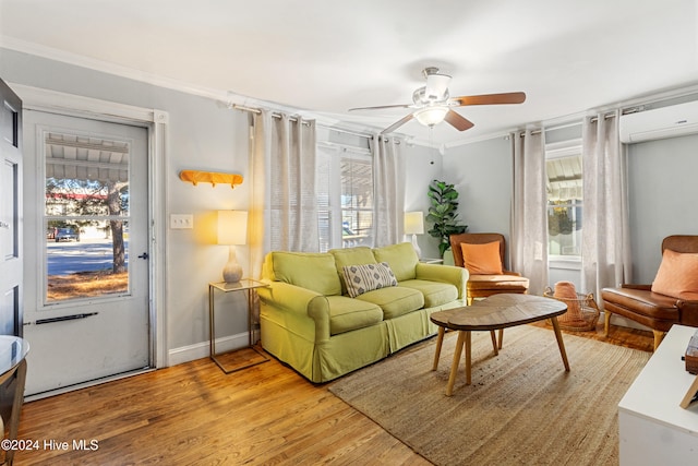 living room with light hardwood / wood-style floors, ornamental molding, and a wall mounted AC