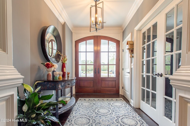 entryway with french doors, crown molding, and dark wood-type flooring