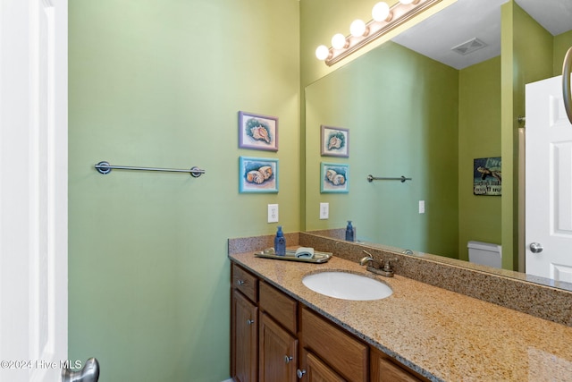 bathroom featuring toilet and vanity