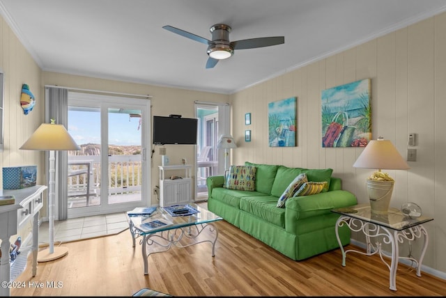 living room with light hardwood / wood-style floors, ornamental molding, and ceiling fan