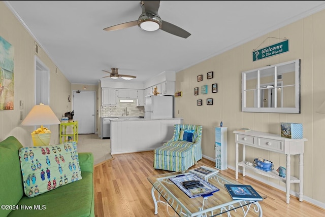 living room featuring sink, crown molding, light hardwood / wood-style flooring, and ceiling fan