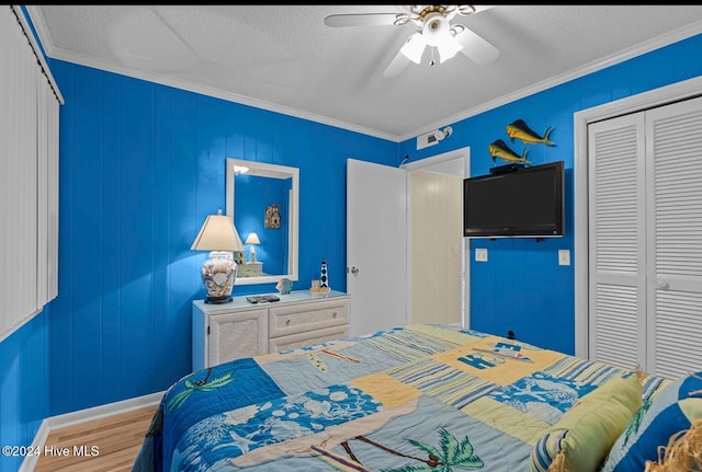 bedroom featuring hardwood / wood-style floors, crown molding, a closet, and ceiling fan