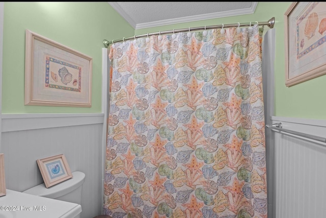 bathroom featuring toilet, crown molding, and a textured ceiling