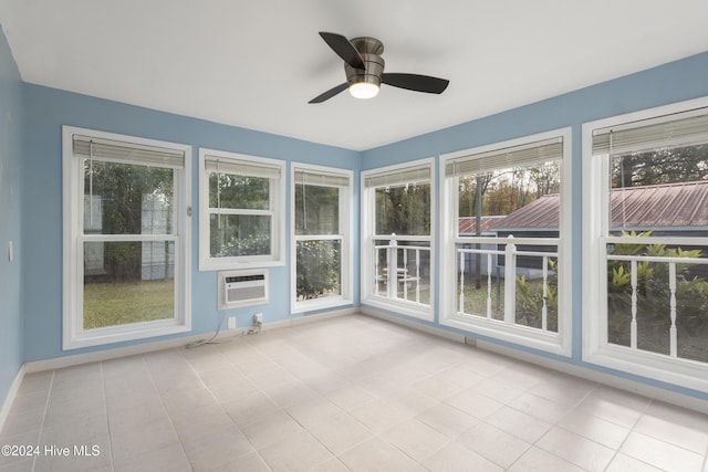 unfurnished sunroom with an AC wall unit and ceiling fan