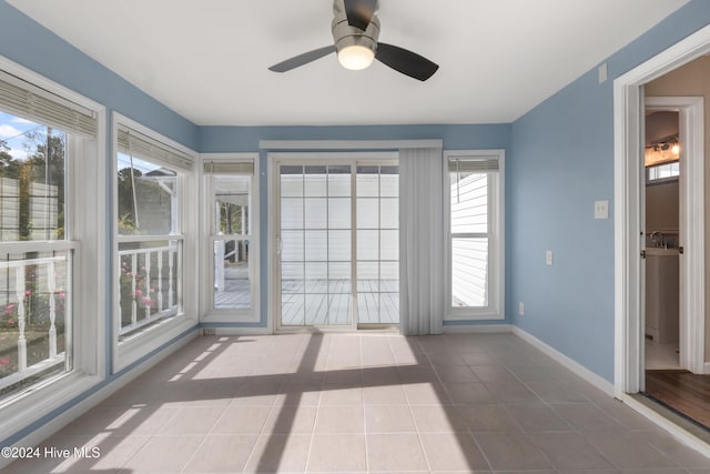 unfurnished sunroom with a wealth of natural light and ceiling fan