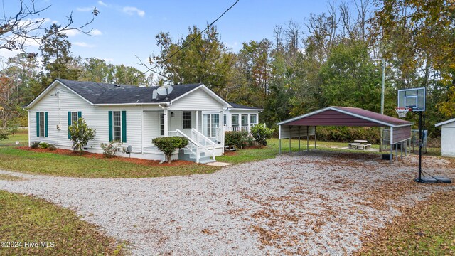 view of front of home with a porch, a carport, and a front yard