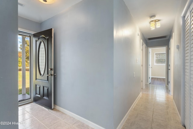 entryway with a healthy amount of sunlight and light tile patterned floors