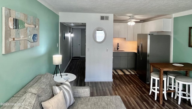 interior space featuring a textured ceiling, ceiling fan, dark hardwood / wood-style flooring, and sink