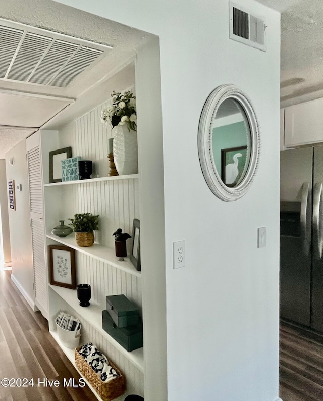 interior space featuring a textured ceiling, stainless steel fridge with ice dispenser, and hardwood / wood-style floors