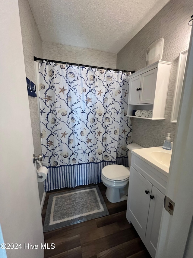 bathroom with a textured ceiling, tasteful backsplash, toilet, wood-type flooring, and vanity