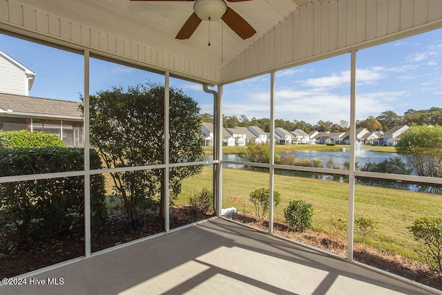 unfurnished sunroom with a water view, ceiling fan, and vaulted ceiling