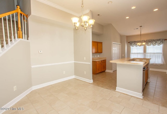 kitchen featuring ornamental molding, an inviting chandelier, pendant lighting, and a center island with sink