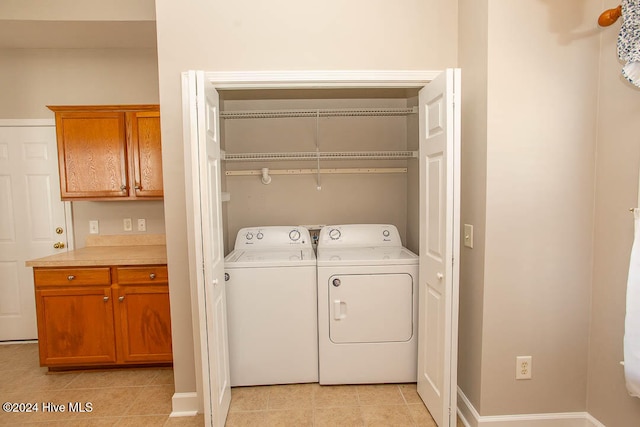 laundry room featuring washing machine and dryer and light tile patterned floors