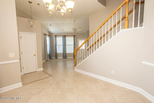 tiled foyer featuring lofted ceiling and ceiling fan with notable chandelier