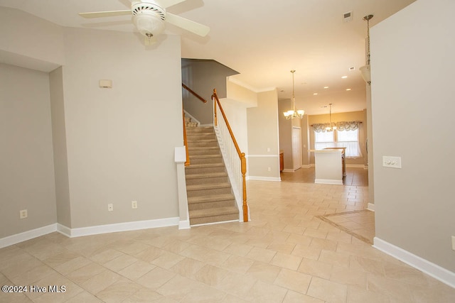 tiled spare room featuring ceiling fan with notable chandelier