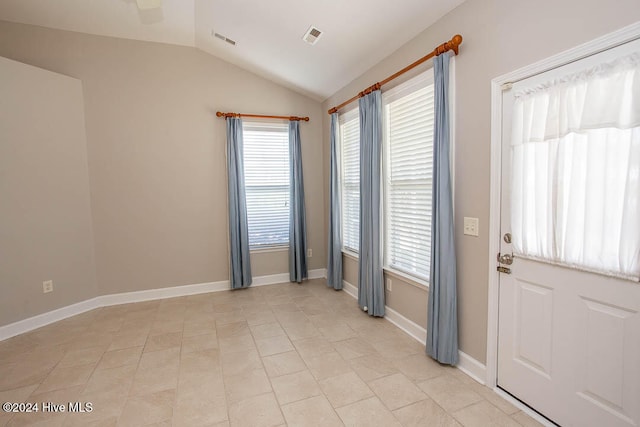 doorway featuring light tile patterned floors and vaulted ceiling