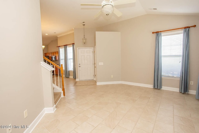 empty room featuring vaulted ceiling, a wealth of natural light, light tile patterned floors, and ceiling fan