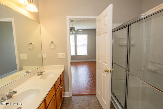 bathroom featuring vanity, a textured ceiling, wood-type flooring, and an enclosed shower