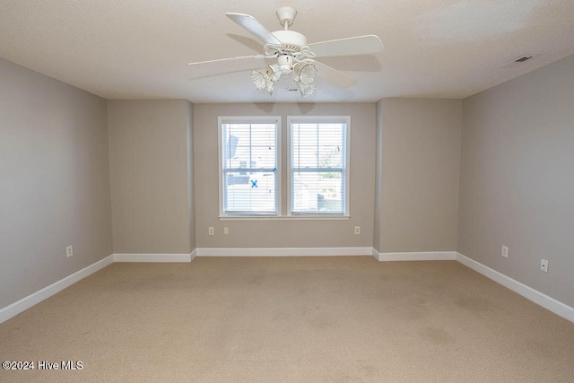 carpeted spare room featuring a textured ceiling and ceiling fan