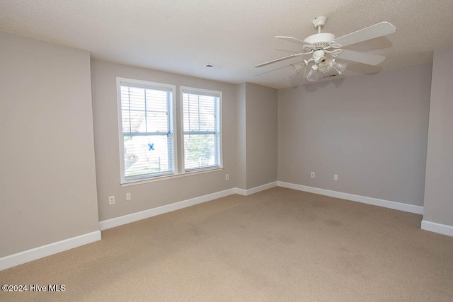 empty room with a textured ceiling, carpet, and ceiling fan