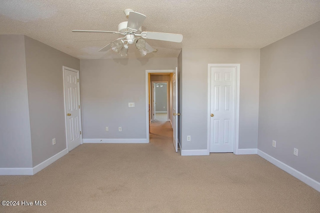 carpeted spare room with a textured ceiling and ceiling fan