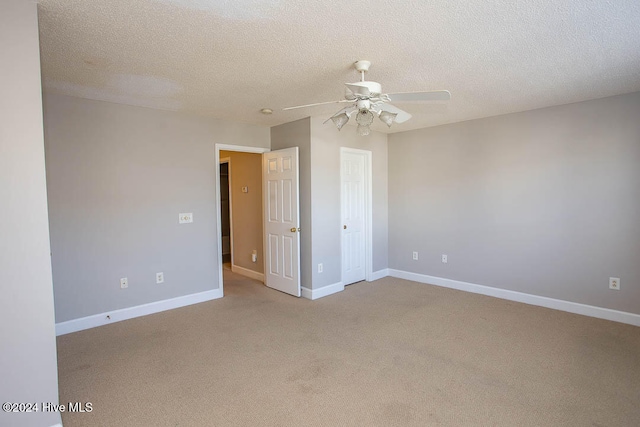 carpeted spare room with a textured ceiling and ceiling fan