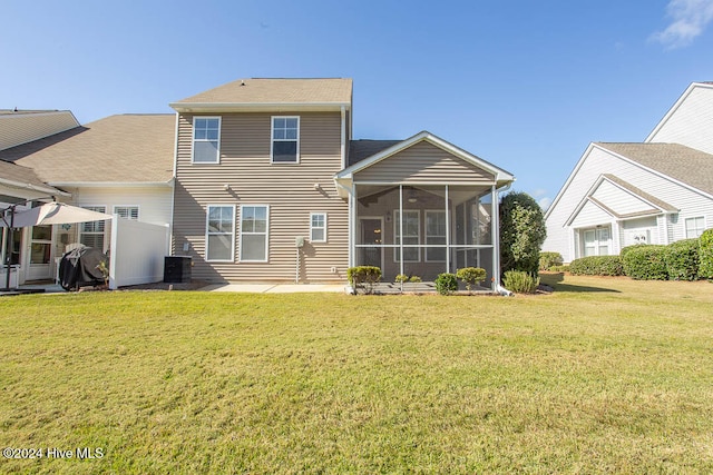 back of house featuring central air condition unit, a lawn, and a sunroom