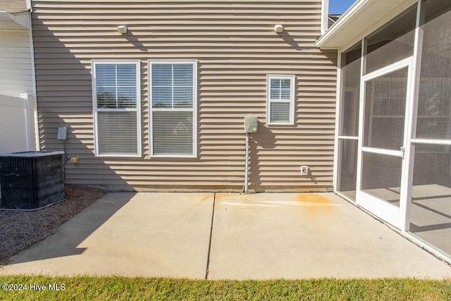 view of patio with cooling unit and a sunroom