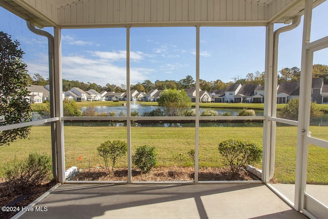 unfurnished sunroom featuring a water view