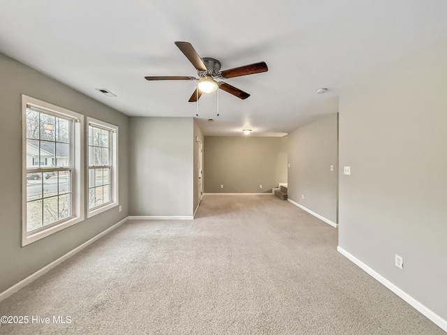 empty room with ceiling fan and light carpet