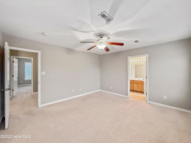 unfurnished bedroom featuring light carpet, connected bathroom, and ceiling fan