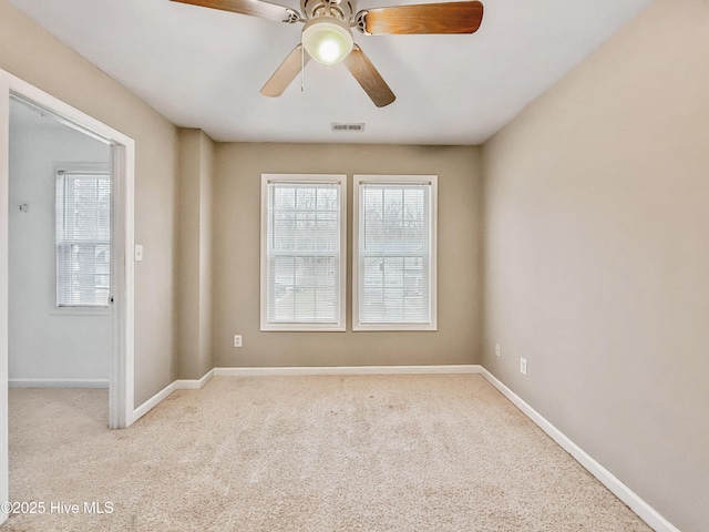 carpeted spare room with ceiling fan