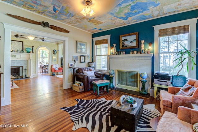 living room with hardwood / wood-style flooring, a healthy amount of sunlight, and a brick fireplace