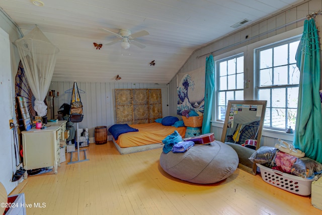 bedroom with wood ceiling, wooden walls, hardwood / wood-style floors, vaulted ceiling, and ceiling fan