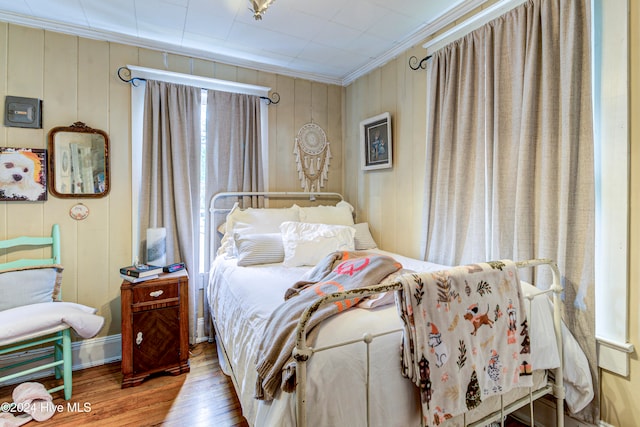 bedroom with ornamental molding and hardwood / wood-style floors