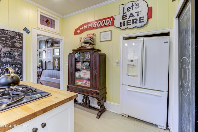 kitchen with white fridge with ice dispenser, wood counters, white cabinetry, light wood-type flooring, and crown molding