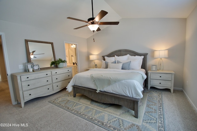 bedroom featuring light colored carpet, vaulted ceiling, ceiling fan, and connected bathroom