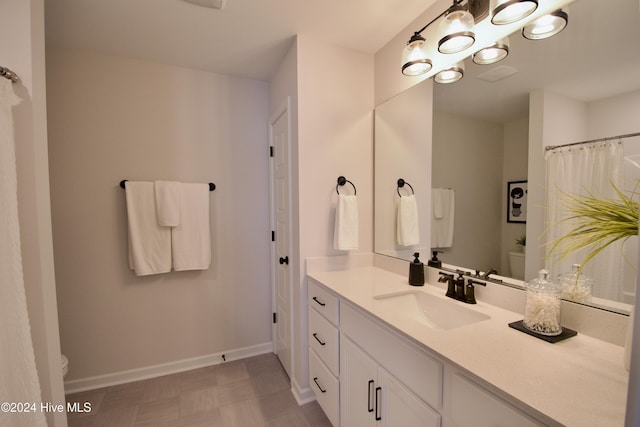 full bathroom featuring toilet, baseboards, vanity, and tile patterned floors