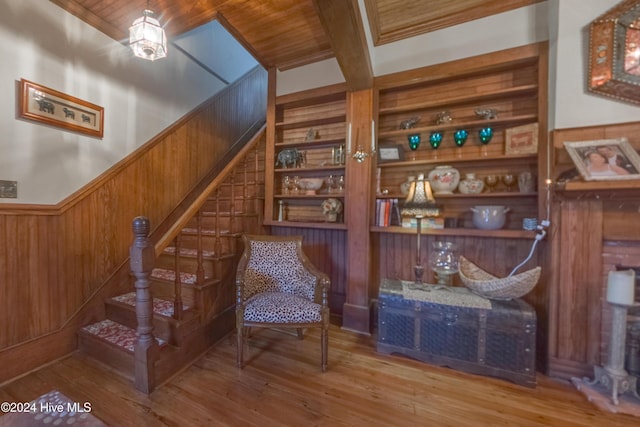 sitting room featuring wooden ceiling, hardwood / wood-style flooring, wood walls, and built in shelves