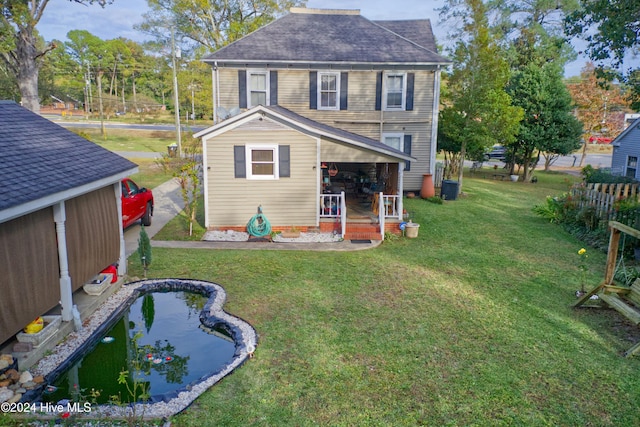 rear view of house featuring a yard and central AC unit