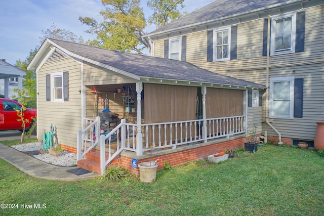 exterior space featuring covered porch and a front lawn