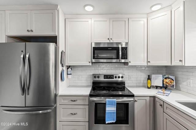 kitchen with appliances with stainless steel finishes, decorative backsplash, and white cabinetry