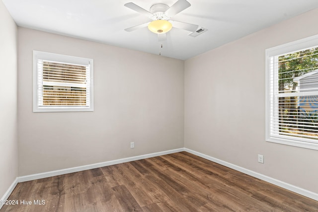 empty room with ceiling fan and dark hardwood / wood-style floors