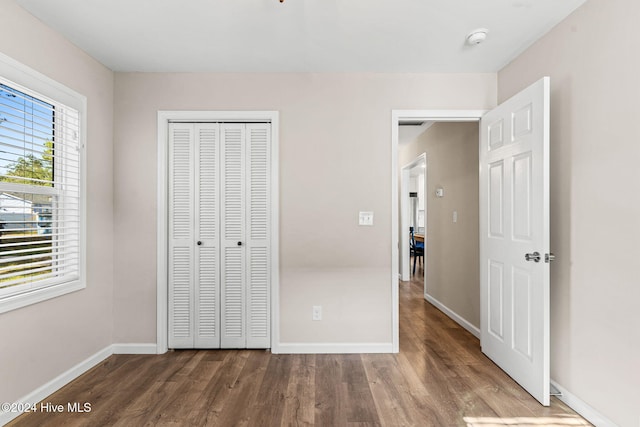 unfurnished bedroom with a closet and wood-type flooring