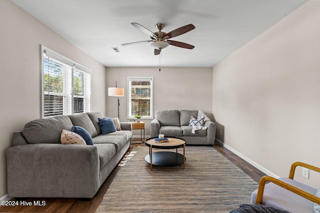 living room featuring ceiling fan and dark hardwood / wood-style flooring